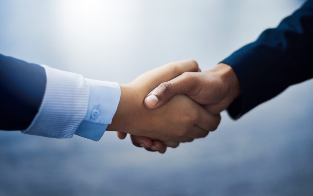 Closeup shot of two unrecognizable businesspeople shaking hands in an office.